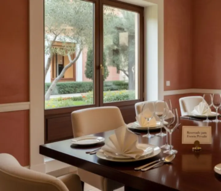 Salón privado del restaurante preparado para una cena con manteles blancos y copas de vino